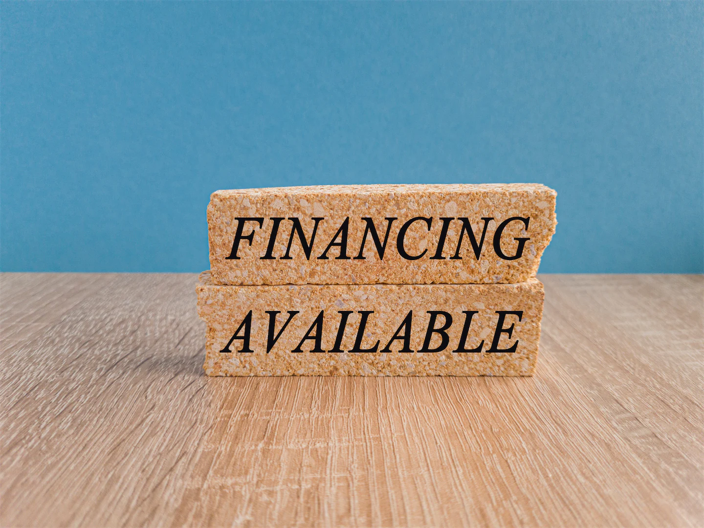 Two cork blocks with “financing available” written on them with blue background