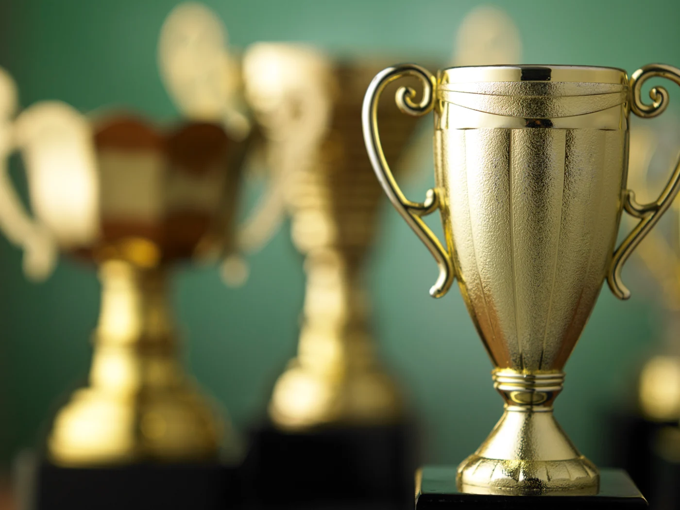 Gold trophy for bathroom remodeling excellence in forefront with more trophies blurred in background