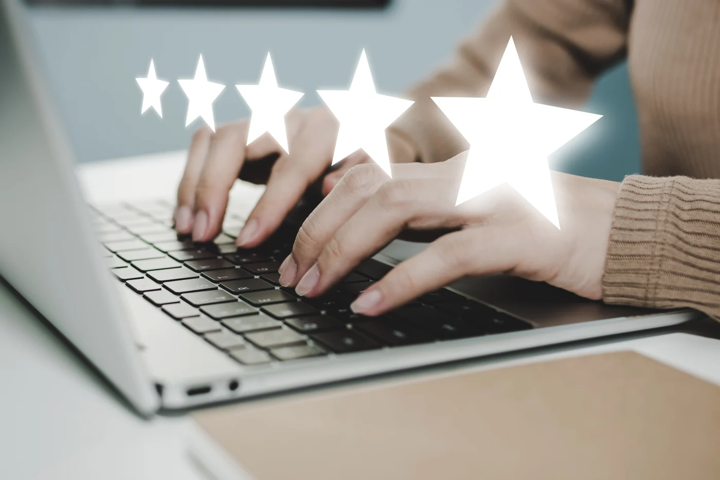Close-up of female hands typing five star review for bay state bath in south shore boston on laptop