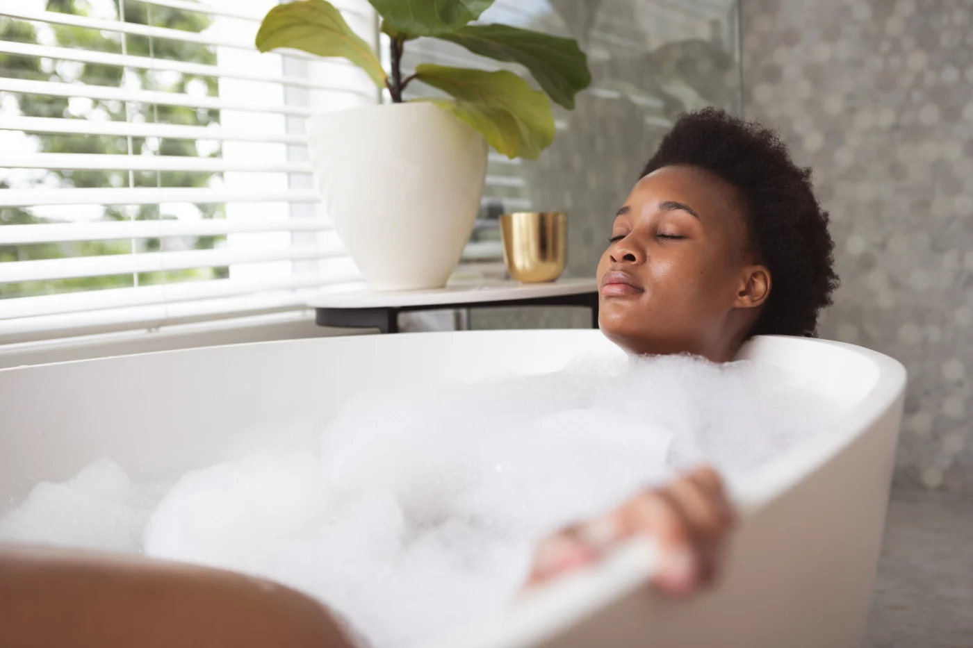 Woman relaxes in newly installed tub after remodel with lifetime warranty