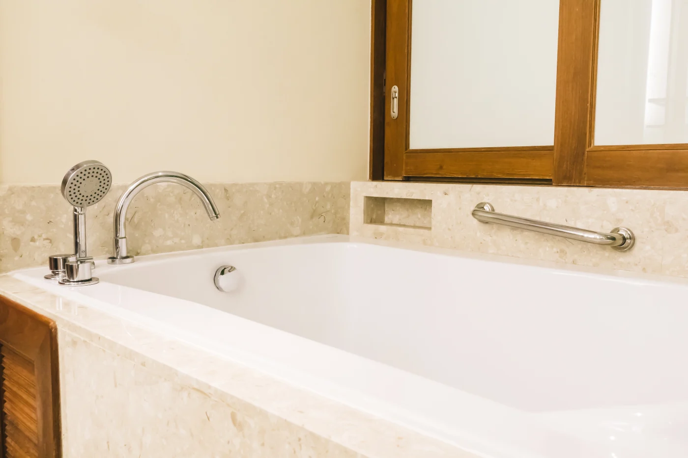 A deep white bathtub with a modern feel.