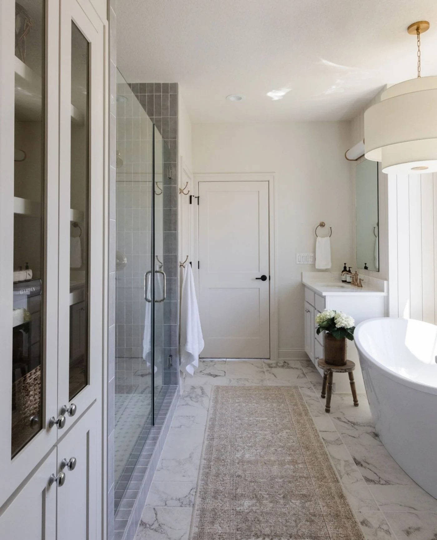 A large Warwick, RI bathroom with a spacious closet and a freestanding tub.
