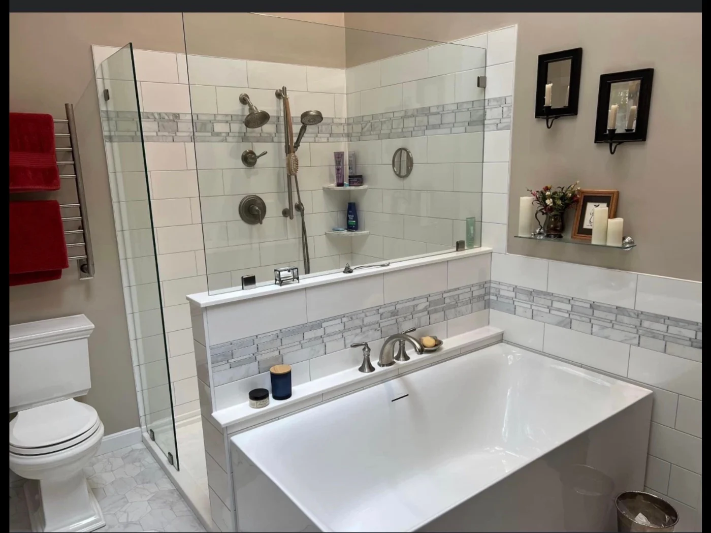 A walk-in shower with glass walls, a white toilet, and a white bathtub.