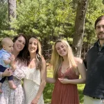 A family photo of the Bylo family in front of trees
