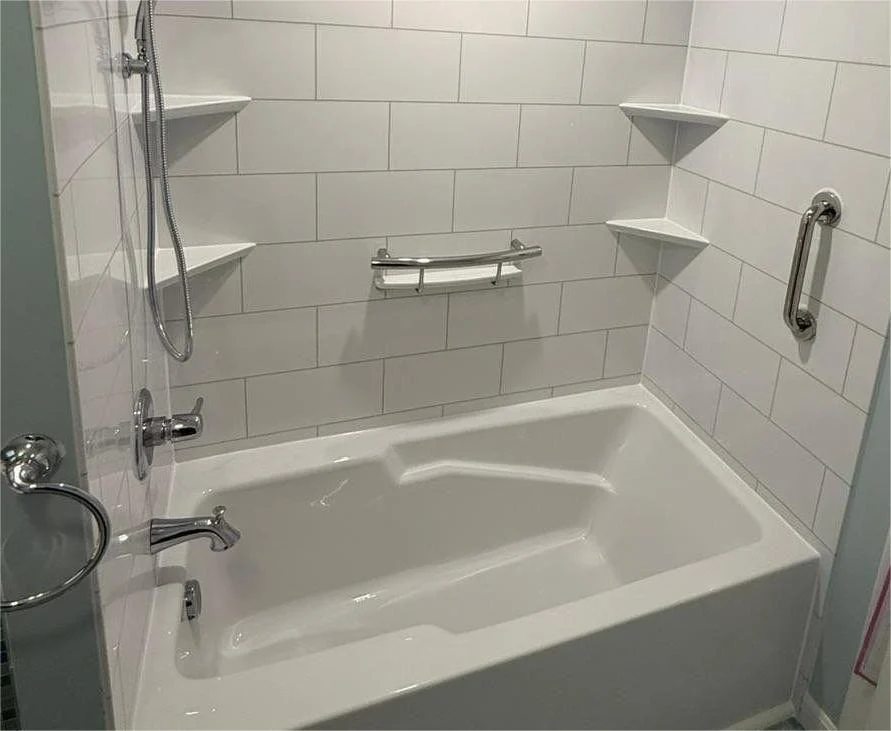 A close-up of a white bathtub with white walls.