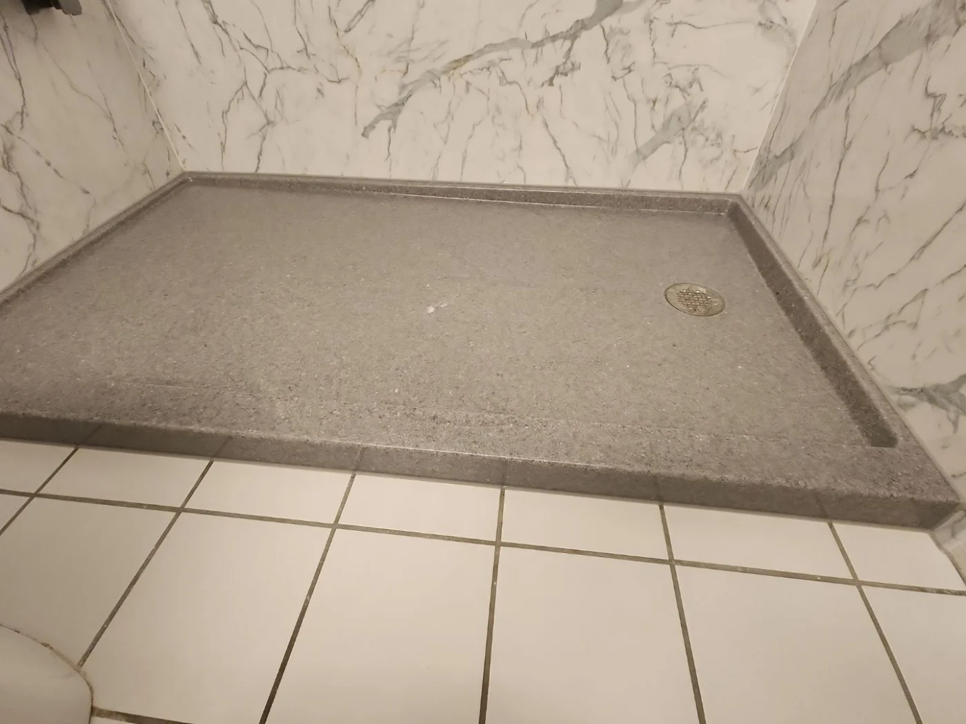 Durable Shower Base & Wall Installation In Quincy, MA | Bay State Bath A close-up of a gray shower base in a white and gray shower.
